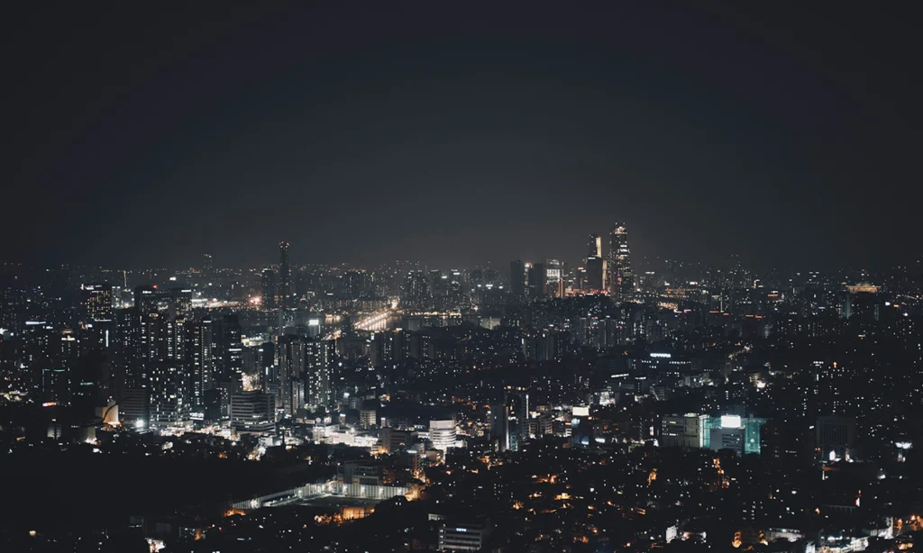 Ilustração de uma cidade iluminada à noite, contexto ideal para explicar como funciona a energia solar à noite com uso de créditos ou baterias.