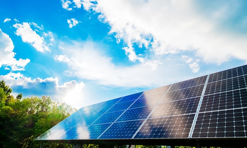 Painéis solares instalados em campo aberto sob céu azul, ilustrando a vida útil das placas solares em ambientes com alta radiação solar.