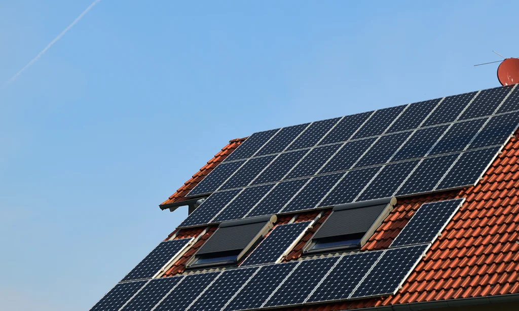 Sistema de energia solar residencial instalado em telhado com telhas cerâmicas, utilizando placas fotovoltaicas para geração própria de eletricidade.
