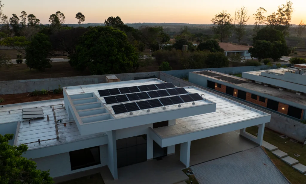 Painéis de energia fotovoltaica residencial captando luz solar em telhado tipo laje, demonstrando a aplicação da energia solar para residência em Brasília.